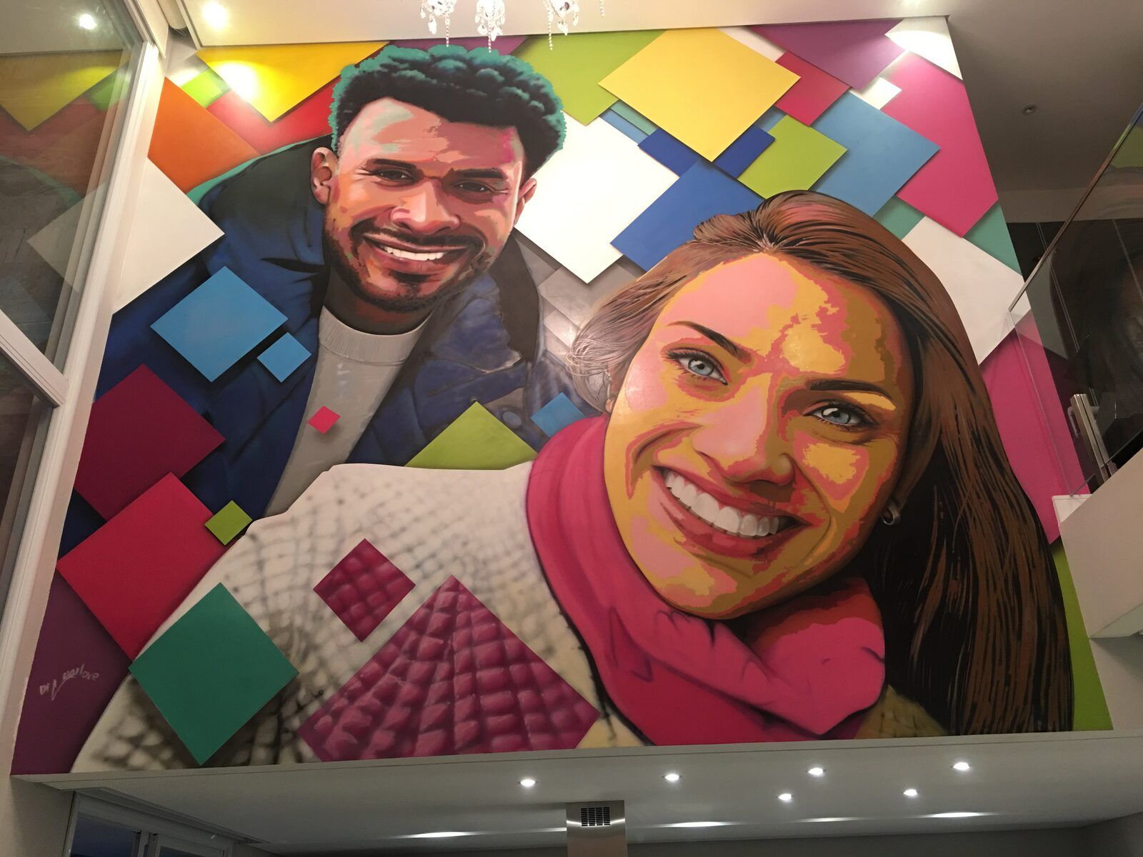 Retrato de casal em mural interno residencial.